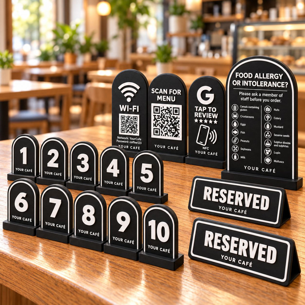 Café Starter Kit in black: ten numbered table signs, Wi-Fi QR sign, menu QR stand, NFC review card, allergen sign and two reserved signs on a café table